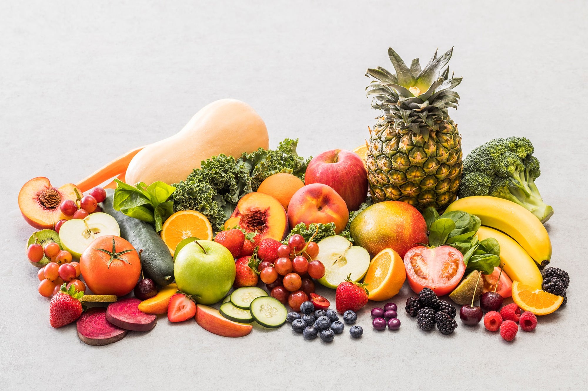 26 different fruits and vegetables on a gray backdrop