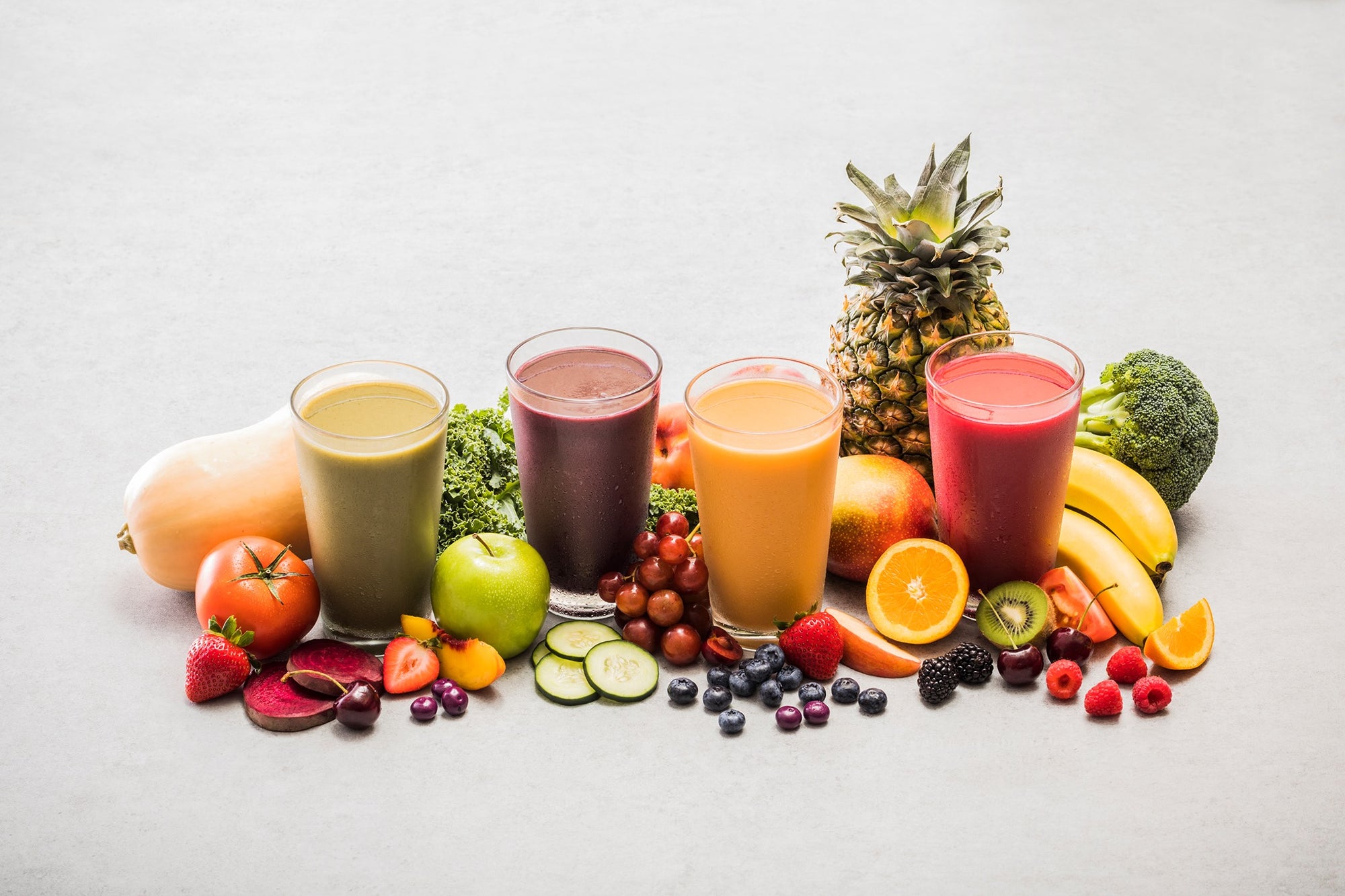 4 Ruvi blend smoothies surrounded by 26 different fruits and vegetables