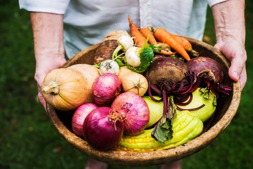 Man holding a large bowl of freshly picked vegetables 