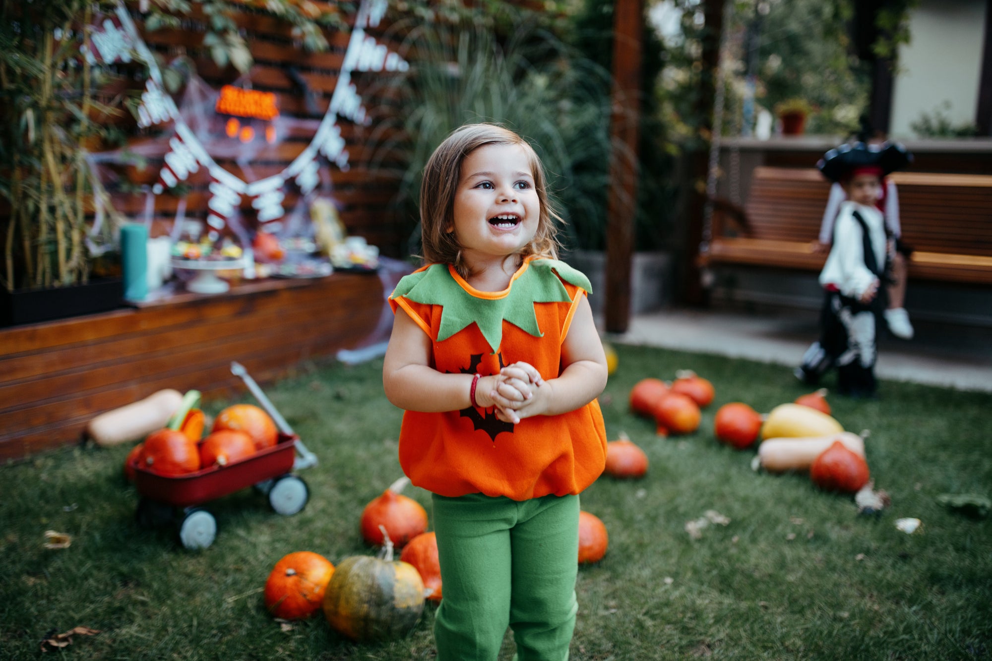 Little child smiling in Halloween jack o'lantern costume
