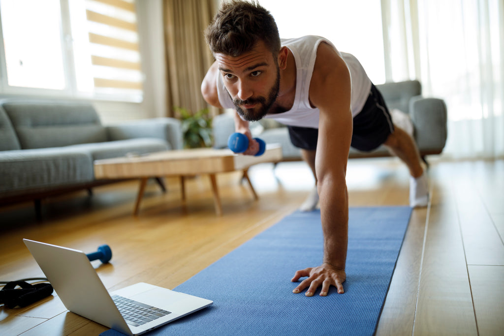 Man exercising holding a dumbbell and doing pushup / lat pulls