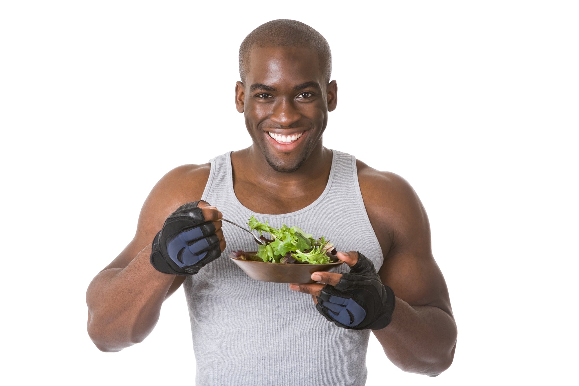 Black man in a gray tank top eating a salad