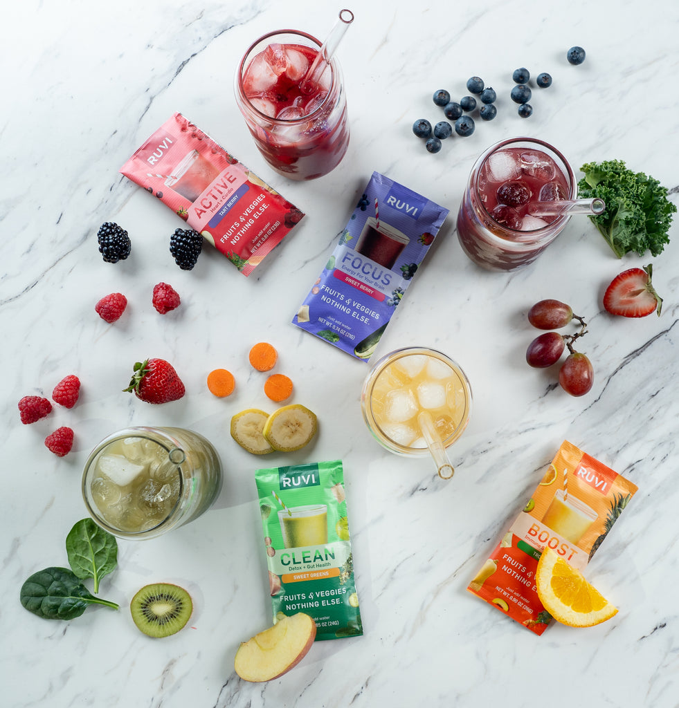 Ruvi with assorted fruits and veggies served in glasses with ice and straws.